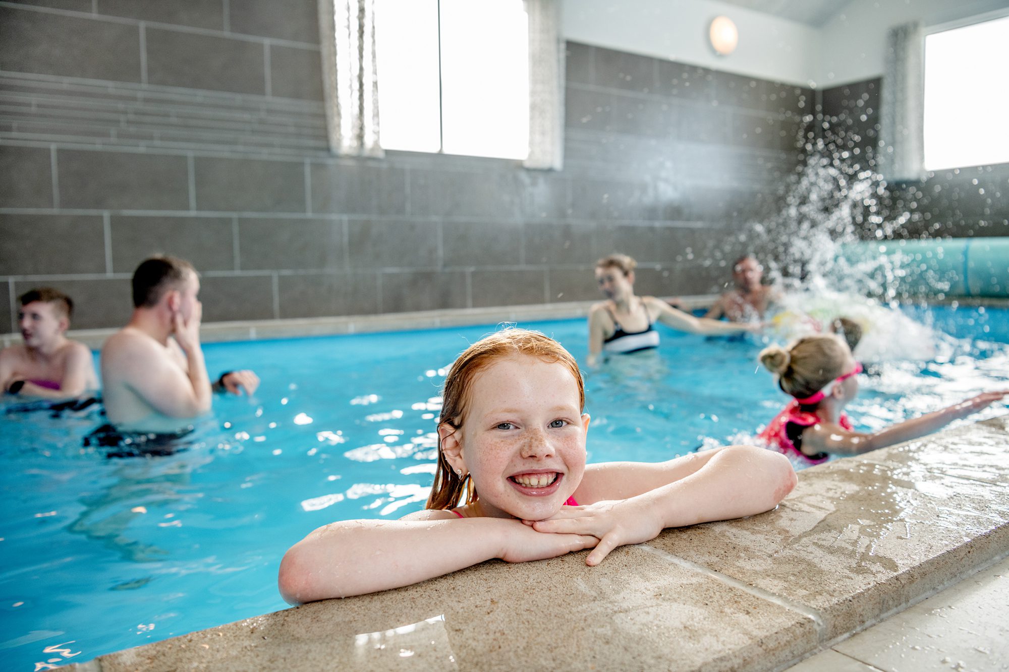Børn og voksne bader i sommerhus med pool