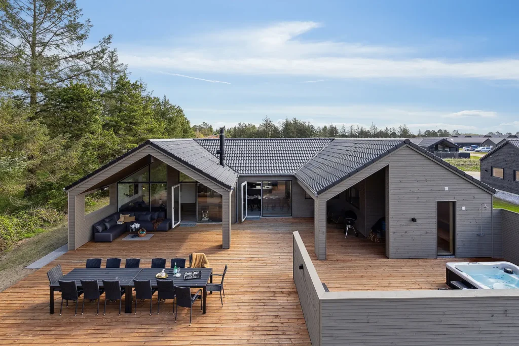 stort luksus-sommerhus med udespa og havemøbler på træterrasse