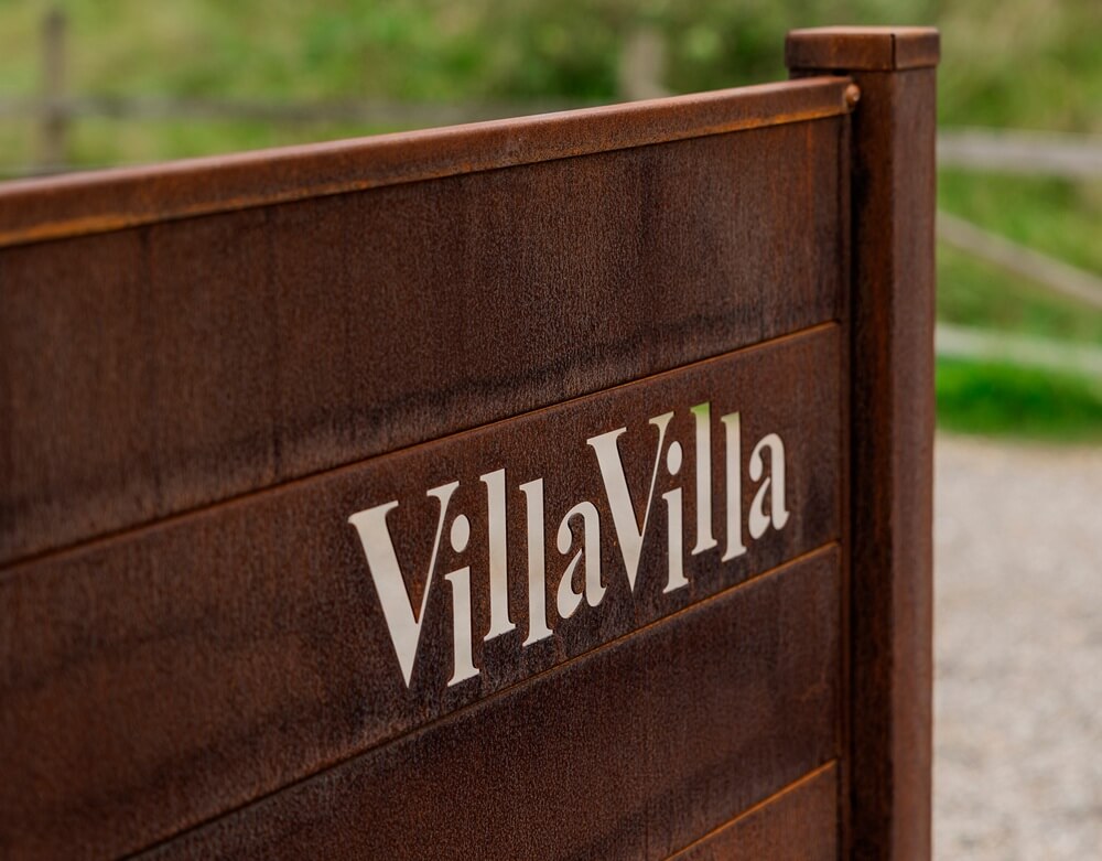 VillaVilla-logo på brunt stakit