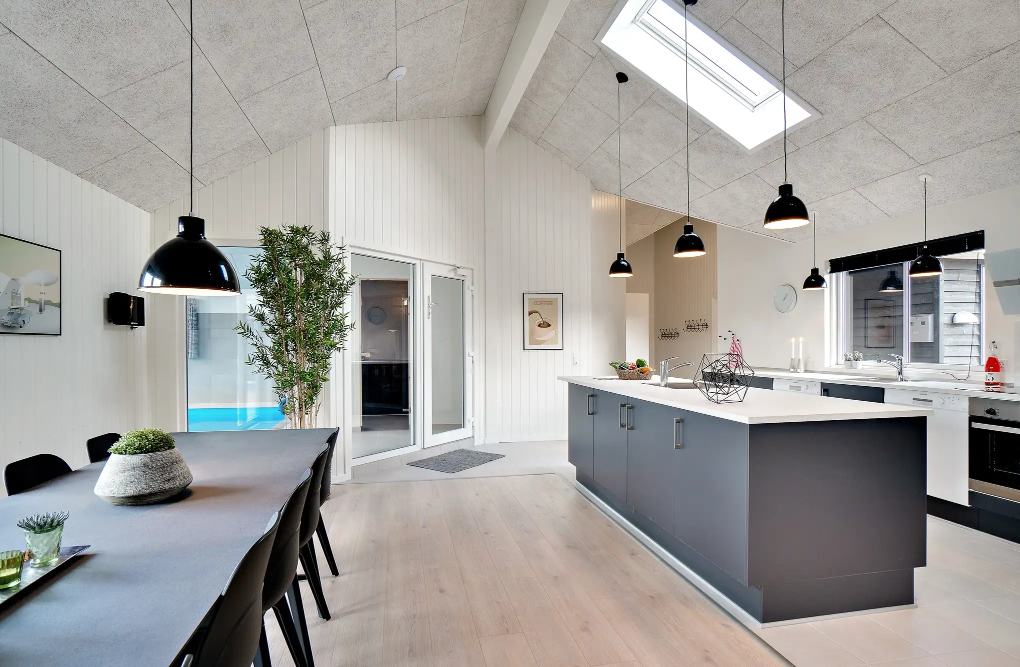 Stort sommerhus med indendørs pool og rummeligt køkken-alrum, perfekt til store familier.